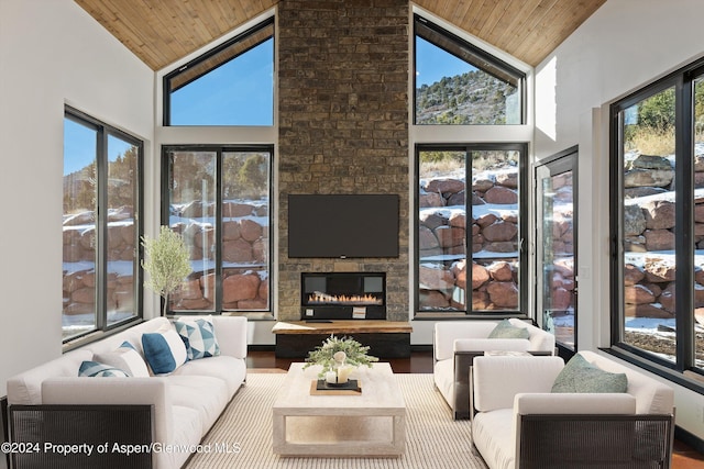 living room featuring hardwood / wood-style floors, a fireplace, high vaulted ceiling, and wood ceiling