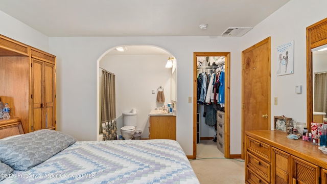 1300 Johnson Way, Craig, CO 81625 - bedroom with arched walkways, light colored carpet, a closet, a spacious closet, and ensuite bathroom