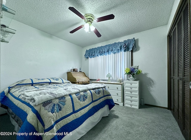 bedroom featuring carpet, a textured ceiling, a closet, and ceiling fan