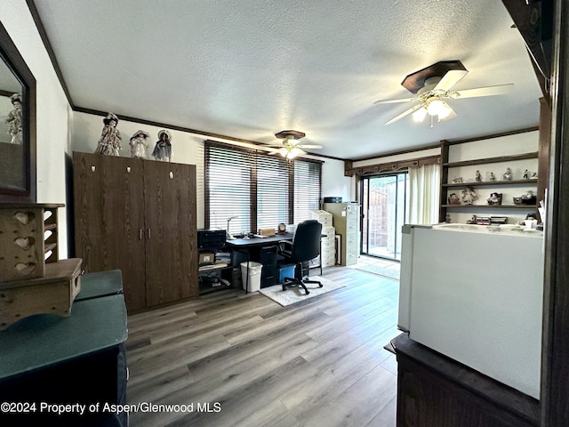 home office featuring a textured ceiling, light hardwood / wood-style flooring, and ceiling fan