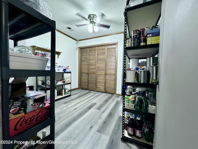 interior space featuring crown molding, hardwood / wood-style flooring, ceiling fan, a textured ceiling, and a closet