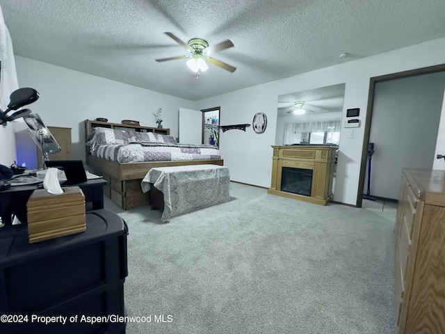 carpeted bedroom with a textured ceiling and ceiling fan