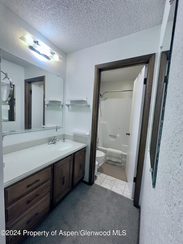 full bathroom featuring tile patterned flooring, tub / shower combination, a textured ceiling, toilet, and vanity