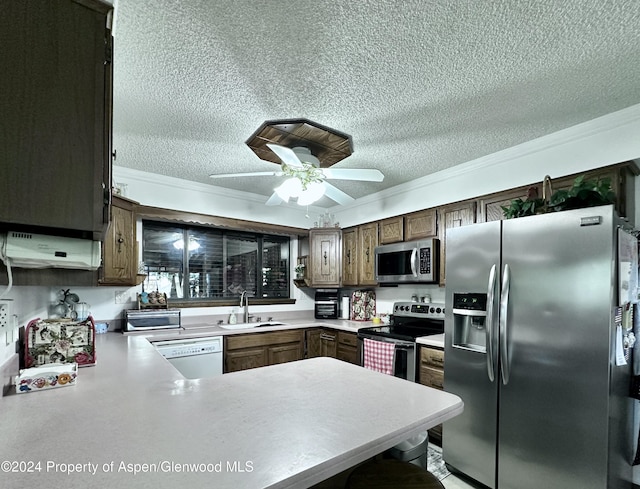 kitchen featuring ceiling fan, sink, kitchen peninsula, appliances with stainless steel finishes, and ornamental molding