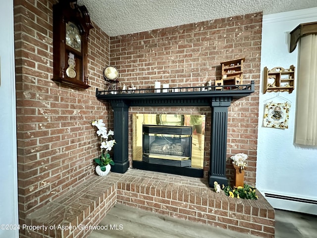 interior details featuring a fireplace, a textured ceiling, and a baseboard heating unit