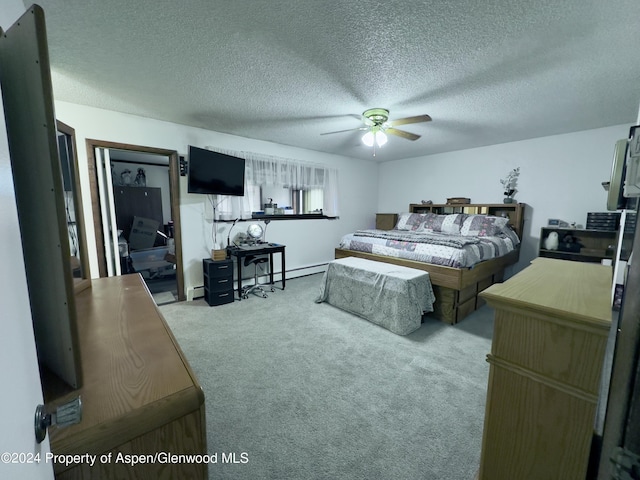 carpeted bedroom with ceiling fan, a baseboard radiator, and a textured ceiling