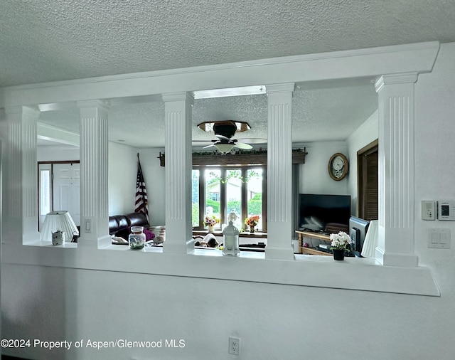 interior space with decorative columns and ceiling fan