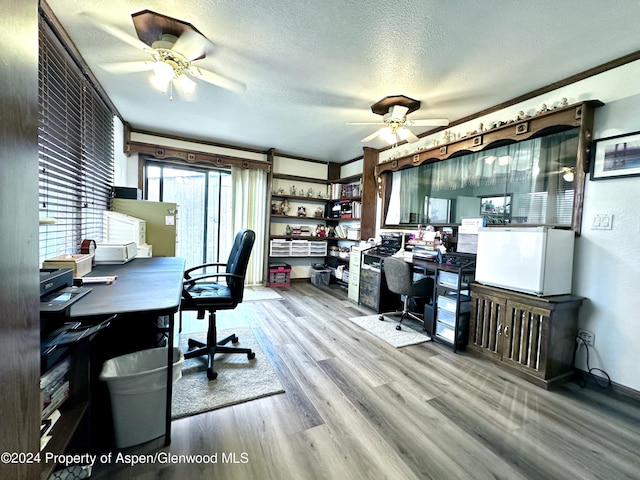 home office with light hardwood / wood-style flooring, a textured ceiling, and ornamental molding