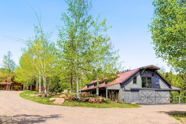 6855 Capitol Creek Rd, Snowmass, CO 81654 - view of front of home featuring dirt driveway, a barn, a detached garage, and an outbuilding