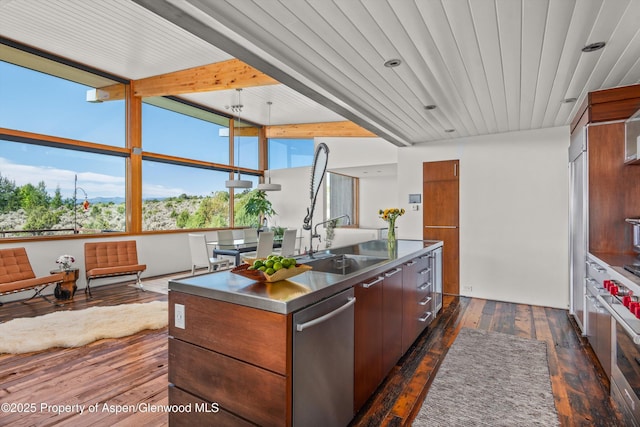 kitchen with dark wood-type flooring, stainless steel countertops, dishwasher, an island with sink, and modern cabinets