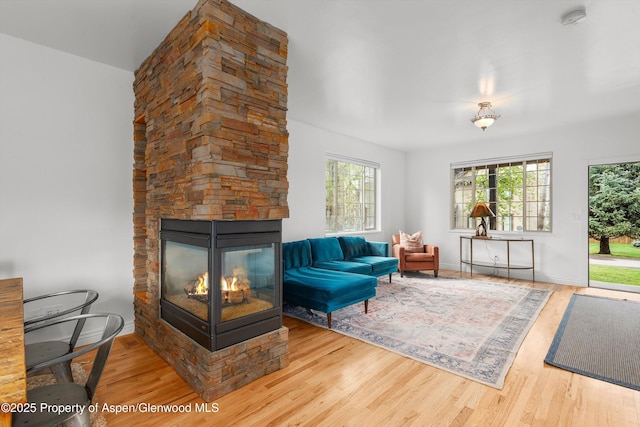 121 Ranch Creek Ln, Carbondale, CO 81623 - living area with wood finished floors, healthy amount of natural light, a stone fireplace, and baseboards