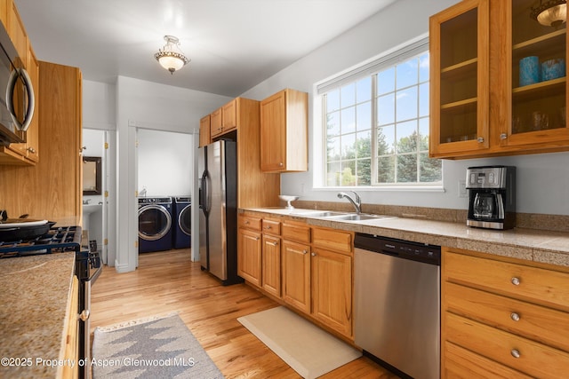 121 Ranch Creek Ln, Carbondale, CO 81623 - kitchen featuring appliances with stainless steel finishes, a sink, separate washer and dryer, tile countertops, and light wood finished floors