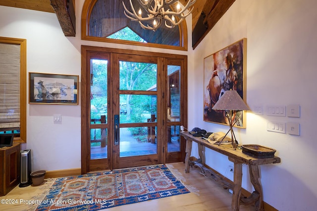 foyer with a chandelier, hardwood / wood-style floors, and high vaulted ceiling