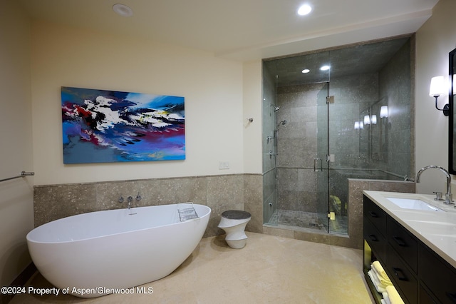 bathroom featuring tile patterned flooring, vanity, independent shower and bath, and tile walls