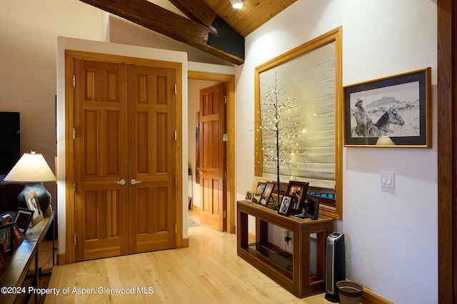 hallway with vaulted ceiling with beams, light hardwood / wood-style flooring, and wooden ceiling