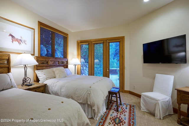 bedroom with access to exterior and light colored carpet