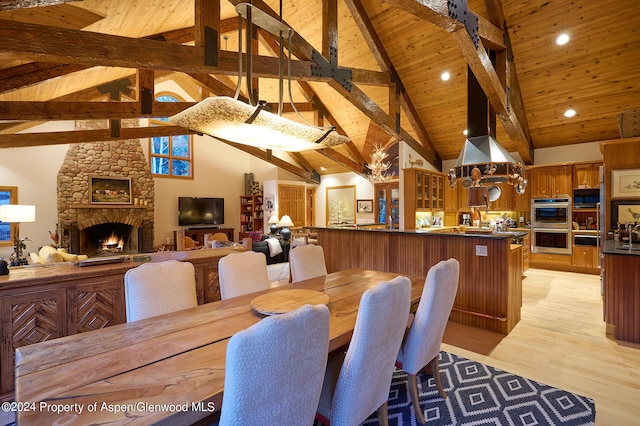 dining space with high vaulted ceiling, light hardwood / wood-style flooring, a fireplace, beamed ceiling, and wood ceiling