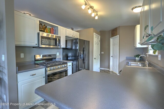 222 Creek Ct, Rifle, CO 81650 - kitchen with stainless steel appliances, white cabinets, open shelves, and a peninsula