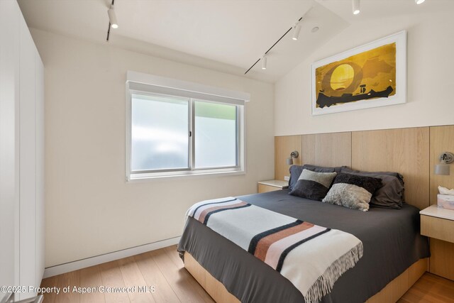 211 W Main St, Aspen, CO 81611 - bedroom with rail lighting and light wood-style floors