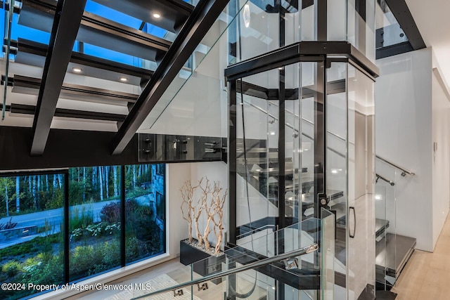 stairs featuring hardwood / wood-style floors and a high ceiling