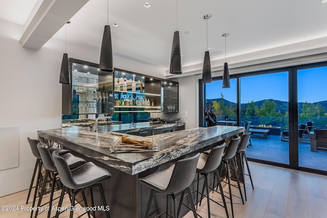 kitchen featuring hardwood / wood-style floors, a mountain view, dark stone countertops, and decorative light fixtures