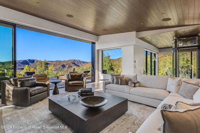 sunroom / solarium featuring a mountain view and wood ceiling