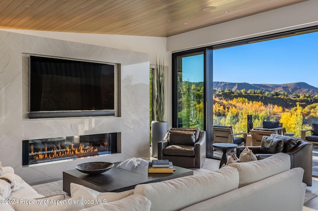 living room featuring a mountain view, wood ceiling, lofted ceiling, and a high end fireplace