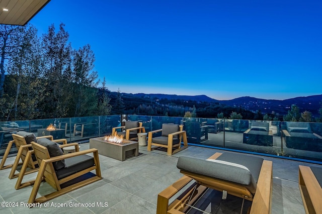 patio terrace at dusk with a fire pit and a mountain view