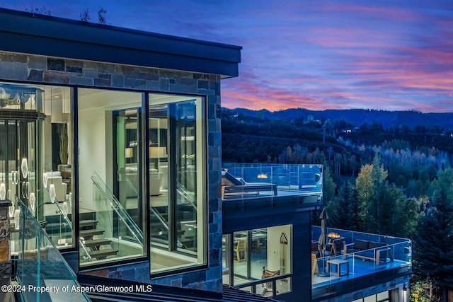 balcony at dusk featuring a mountain view