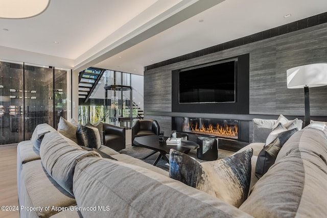 living room featuring hardwood / wood-style flooring and a large fireplace