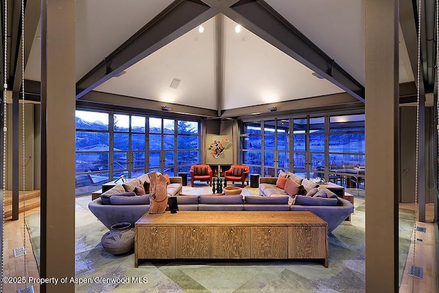 living room featuring beamed ceiling, high vaulted ceiling, and visible vents