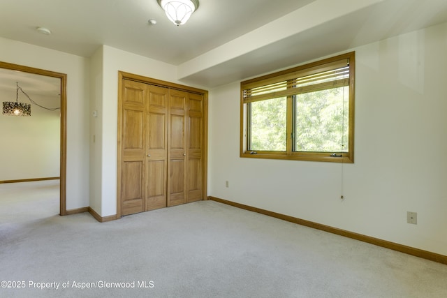 201 14th St Unit 300, Glenwood Springs, CO 81601 - unfurnished bedroom featuring carpet floors, a closet, baseboards, and a chandelier