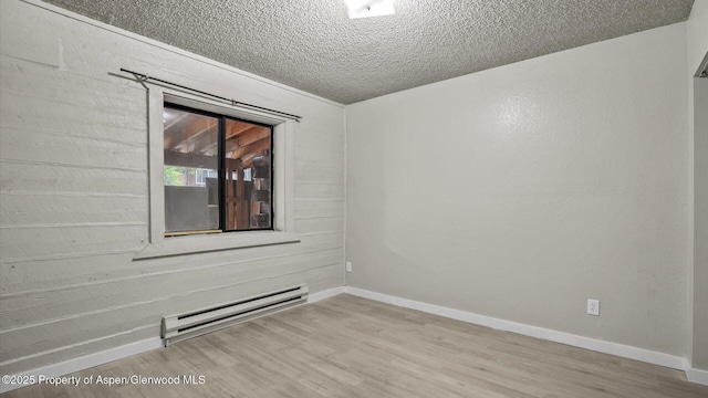 200 S E Ave Unit 111, New Castle, CO 81647 - spare room featuring a baseboard radiator, wood finished floors, and a textured ceiling