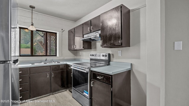 200 S E Ave Unit 111, New Castle, CO 81647 - kitchen featuring stainless steel appliances, under cabinet range hood, light countertops, dark brown cabinetry, and hanging light fixtures