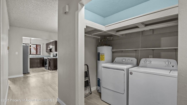 200 S E Ave Unit 111, New Castle, CO 81647 - laundry room featuring water heater, washer and clothes dryer, light wood-style flooring, and a textured ceiling