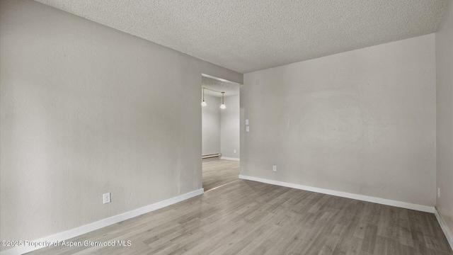 200 S E Ave Unit 111, New Castle, CO 81647 - empty room featuring wood finished floors, a textured ceiling, and a baseboard radiator