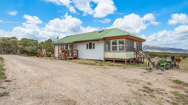 2051 Grass Mesa Rd, Rifle, CO 81650 - view of front of house featuring a deck with mountain view, metal roof, and a sunroom