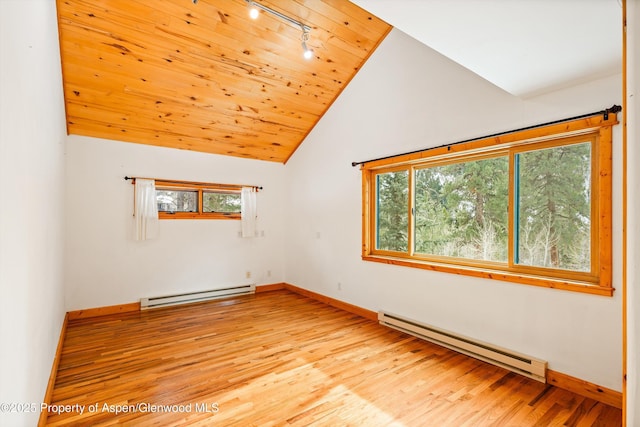 unfurnished room with lofted ceiling, baseboard heating, and a wealth of natural light