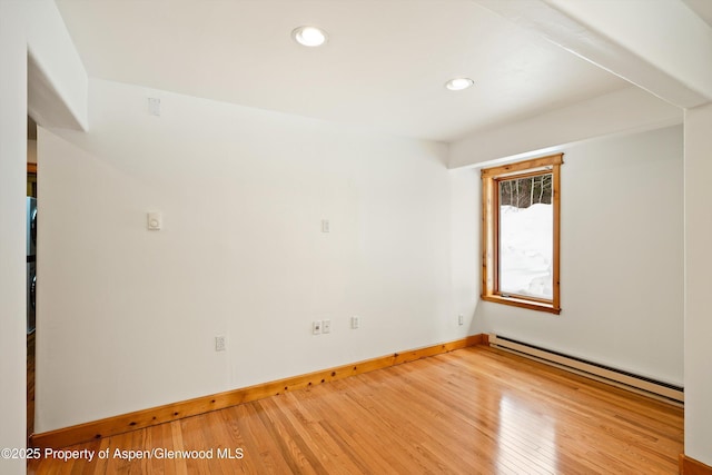 unfurnished room featuring baseboards, baseboard heating, wood finished floors, and recessed lighting