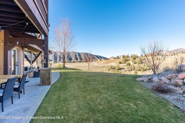 view of yard with a patio and a mountain view