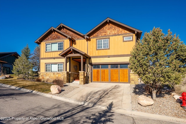 craftsman inspired home with stone siding, board and batten siding, and driveway