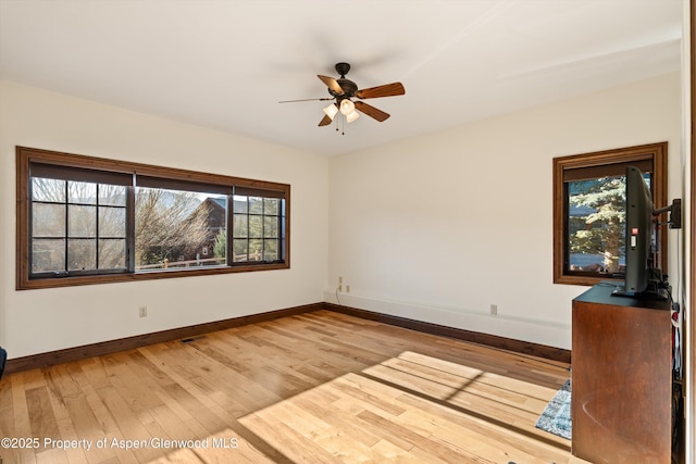 unfurnished room with light wood-type flooring, baseboards, and ceiling fan