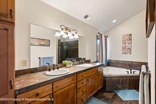 bathroom with a sink, visible vents, a bath, and vaulted ceiling