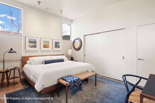 bedroom with visible vents, a closet, and wood finished floors