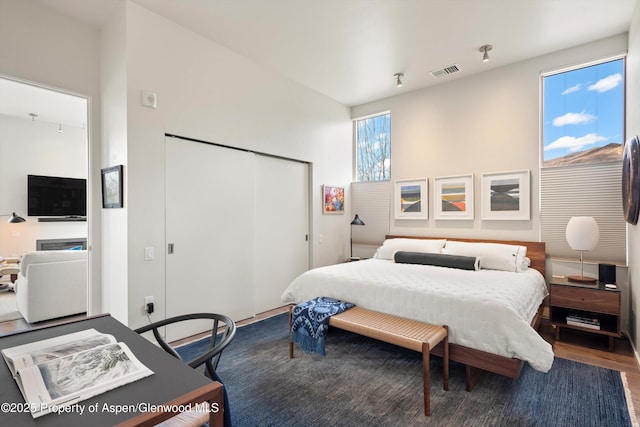 bedroom featuring a closet, visible vents, and wood finished floors