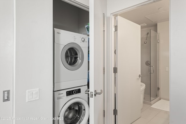 washroom featuring light tile patterned floors, laundry area, and stacked washing maching and dryer