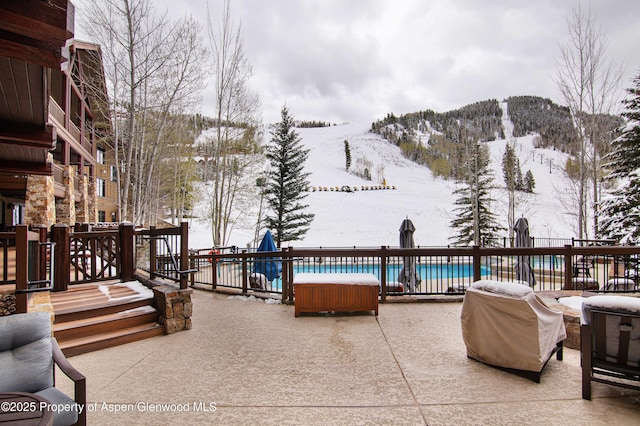 exterior space with a grill, a mountain view, and a pool