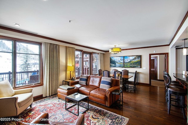 living room with baseboards, ornamental molding, and wood finished floors