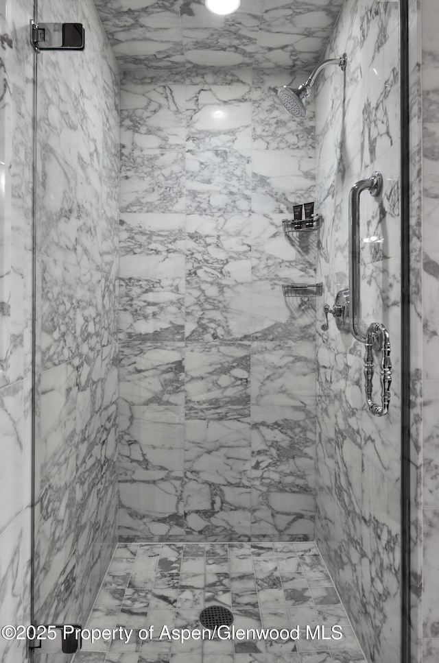 full bath with a marble finish shower