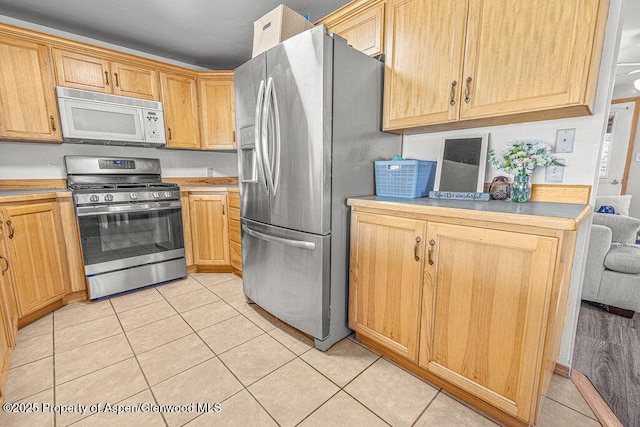 5904 County Road 31, Craig, CO 81625 - kitchen with stainless steel appliances, light countertops, and light tile patterned flooring